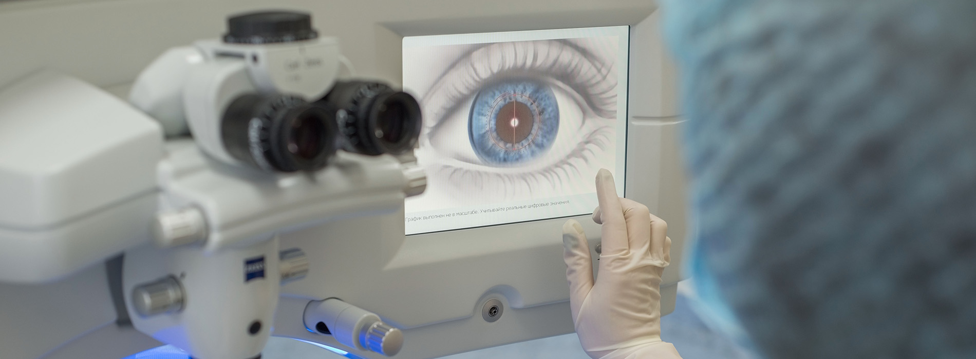 The image shows a person examining an eye with a magnified view through a microscope, likely in a medical setting.